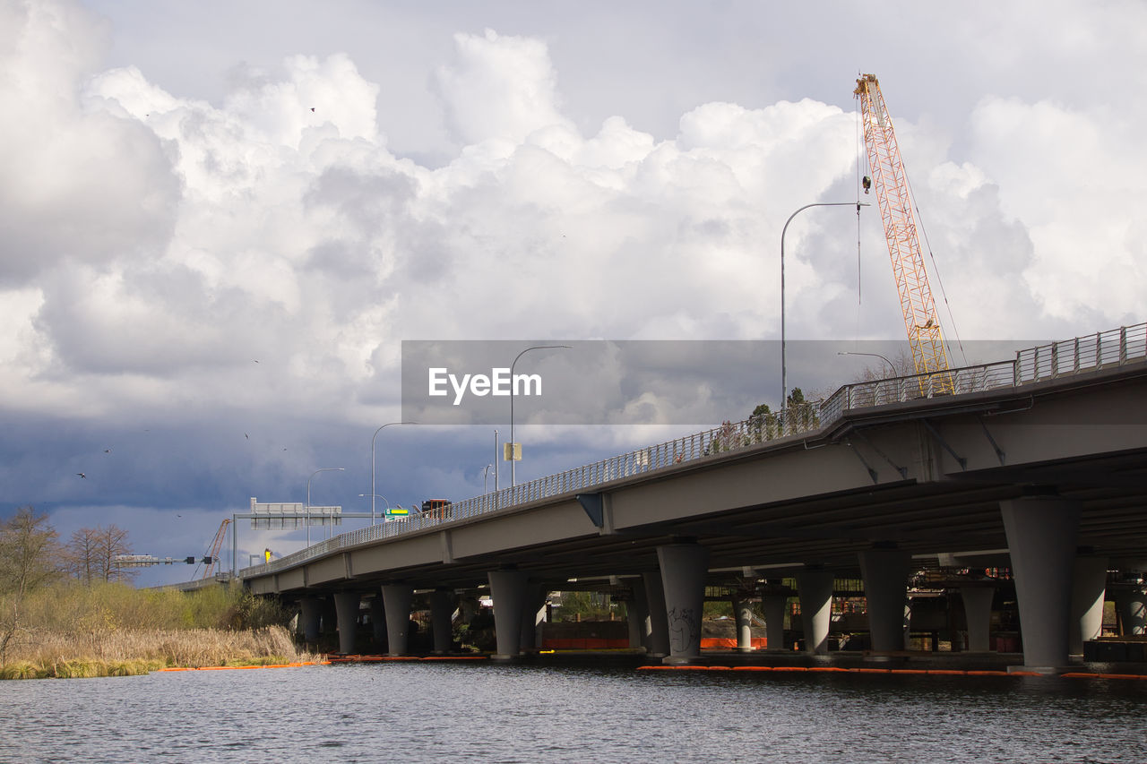 cloud, transport, architecture, sky, bridge, built structure, transportation, water, nature, vehicle, industry, no people, outdoors, day, travel, river, city, building exterior, mode of transportation, business, travel destinations, environment, business finance and industry