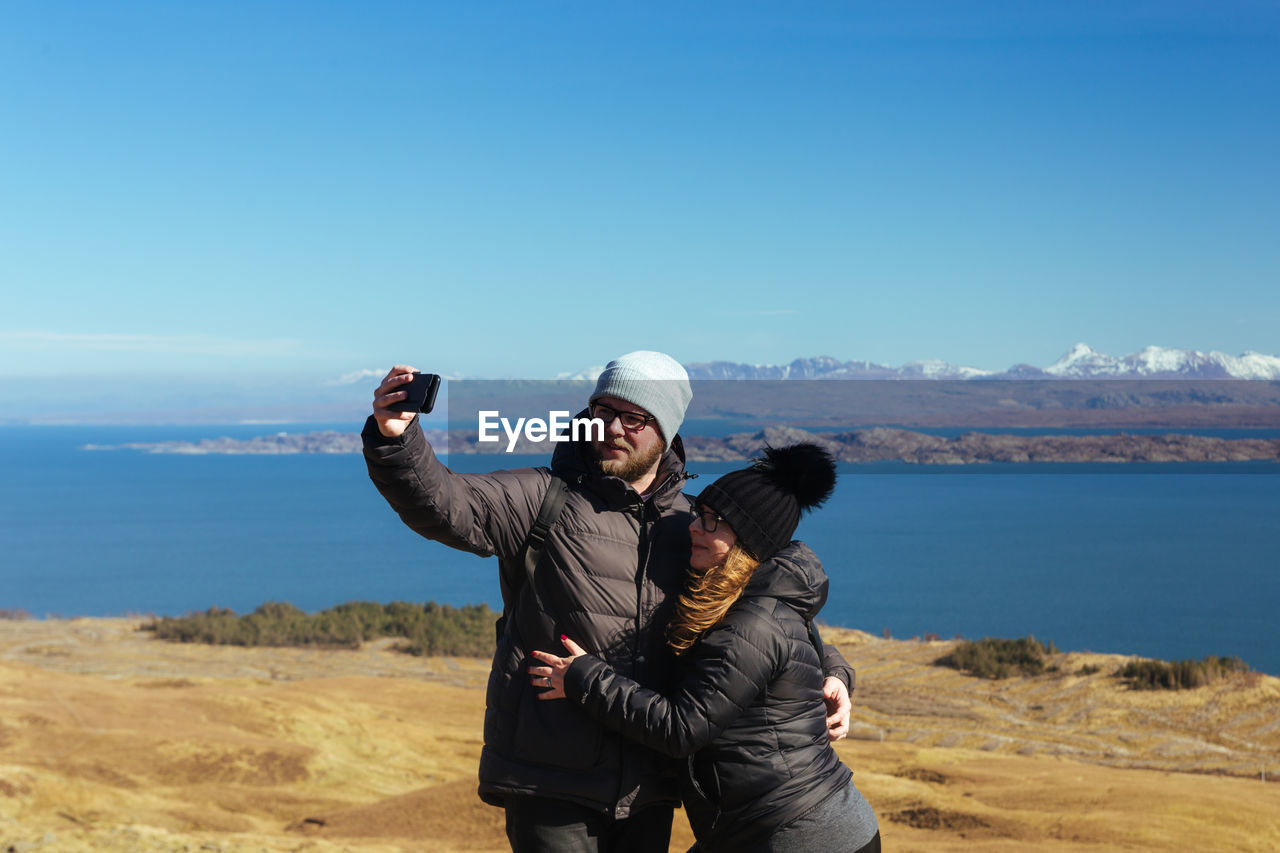 Couple taking selfie while standing on land
