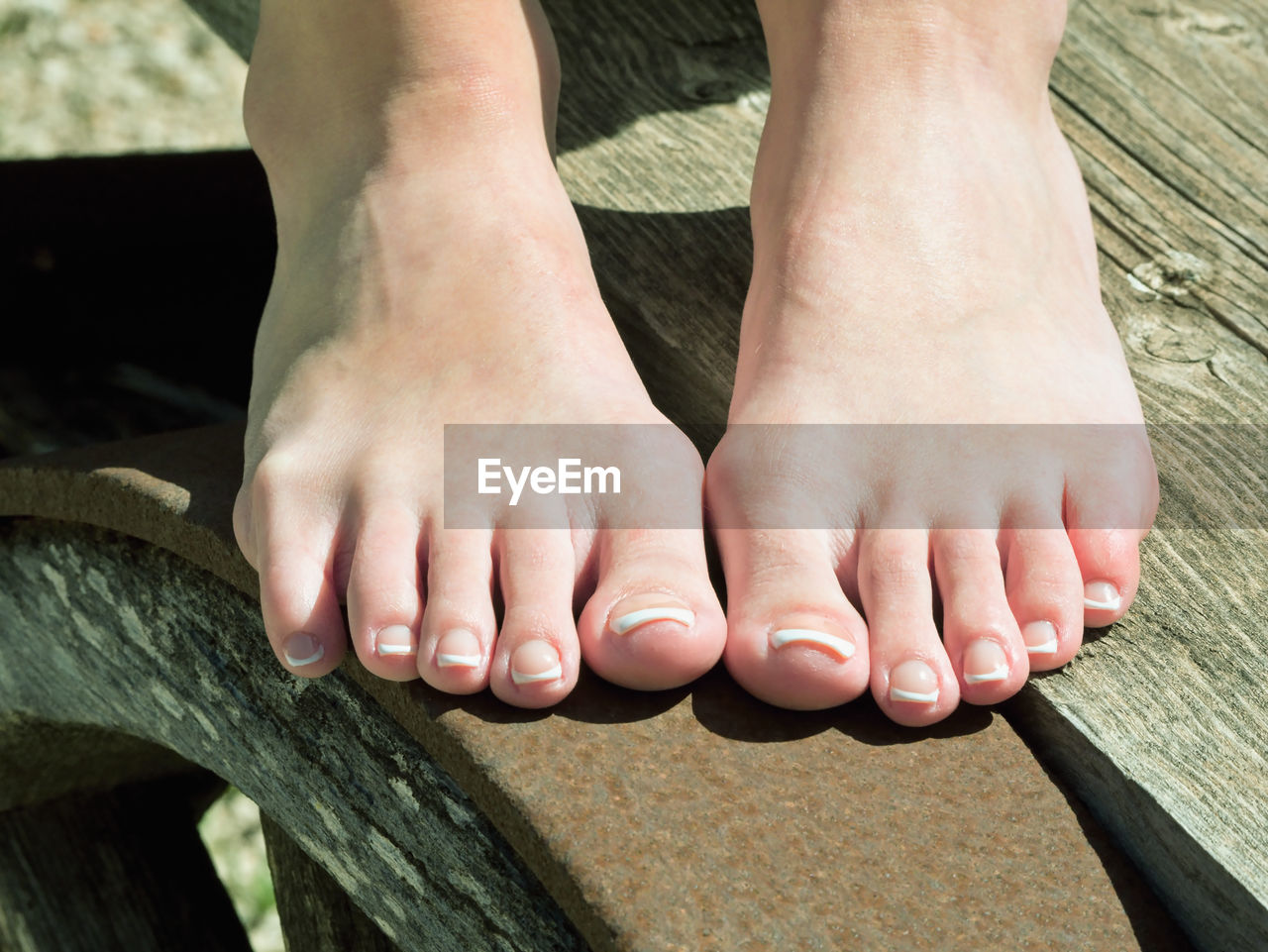 Low section of woman feet on wood