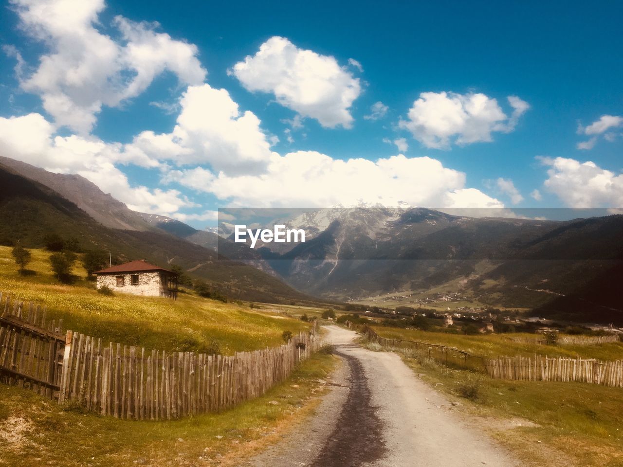 Road leading towards mountains against sky