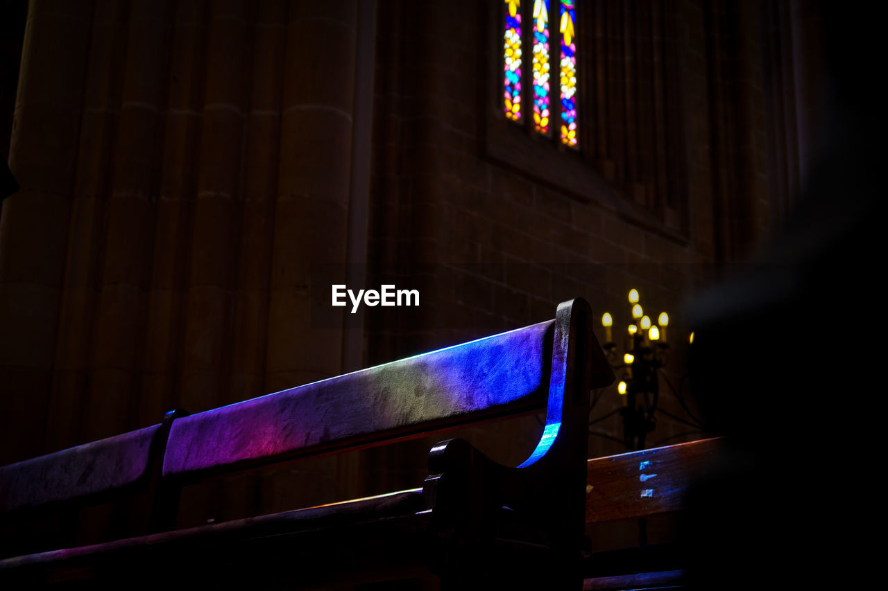 Empty bench in church at night