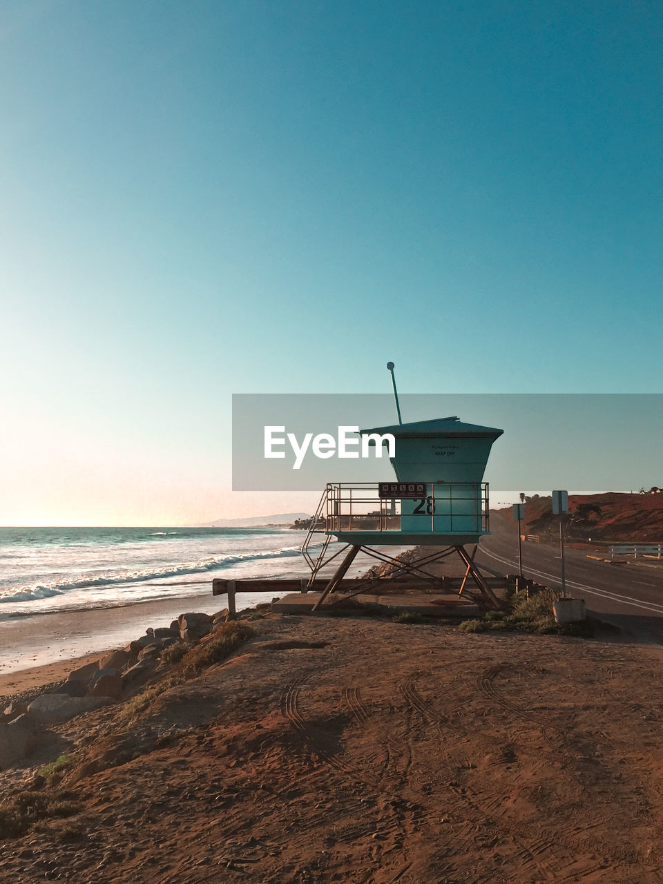 LIFEGUARD HUT ON SANDY BEACH AGAINST CLEAR SKY