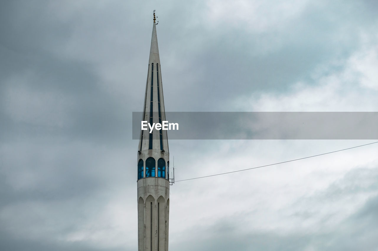 Low angle view of cross on building against sky