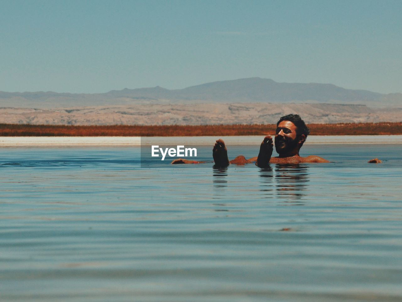 Portrait of smiling young woman swimming in water