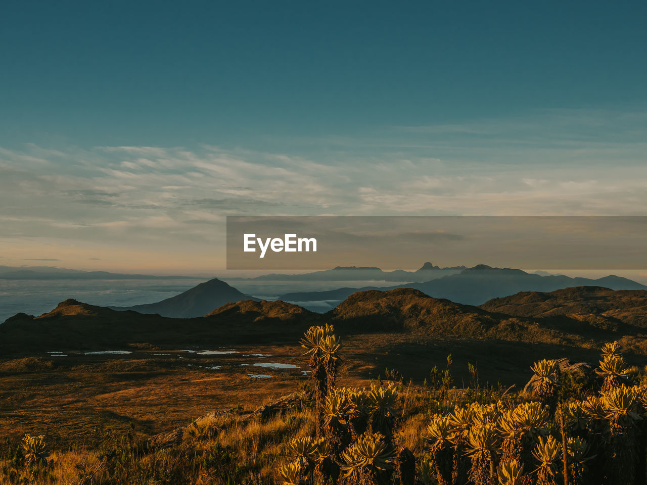 SCENIC VIEW OF LAND AND MOUNTAINS AGAINST SKY DURING SUNSET