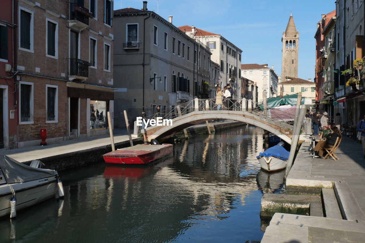 architecture, water, canal, built structure, building exterior, nautical vessel, transportation, mode of transportation, city, bridge, waterway, travel destinations, boat, gondola, travel, town, nature, body of water, tourism, vehicle, reflection, watercraft, cityscape, building, channel, sky, vacation, trip, holiday, day, gondolier, moored, tourist, outdoors, craft, street, old, history, waterfront