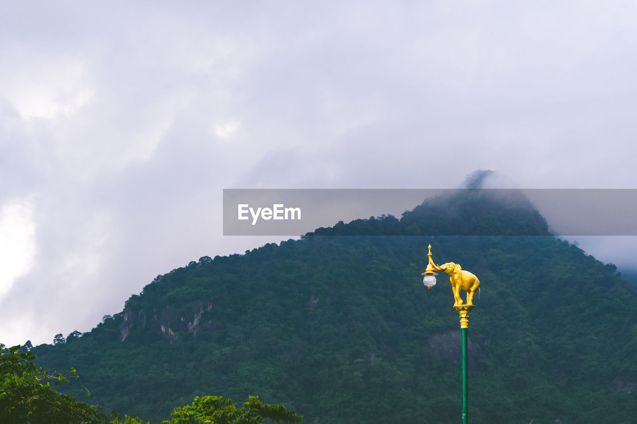 A golden elephant with a mountain background at nakhonnayok, thailand