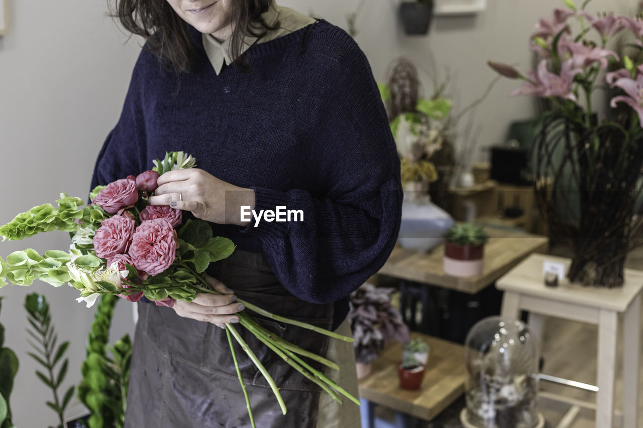 Midsection of woman holding flower bouquet