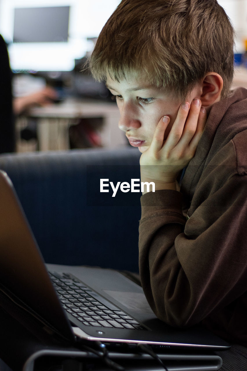 Close-up of boy using laptop