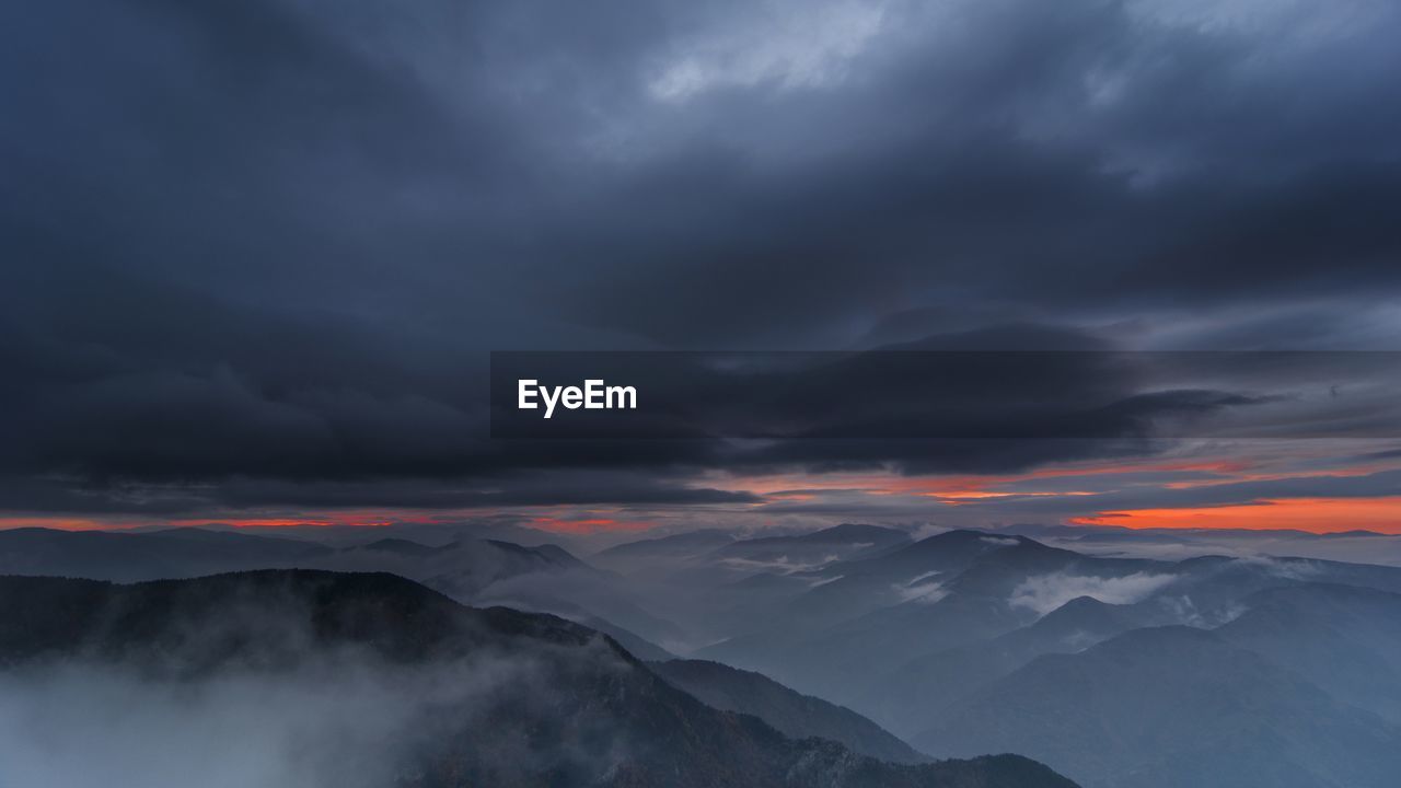 Scenic view of mountains against dramatic sky