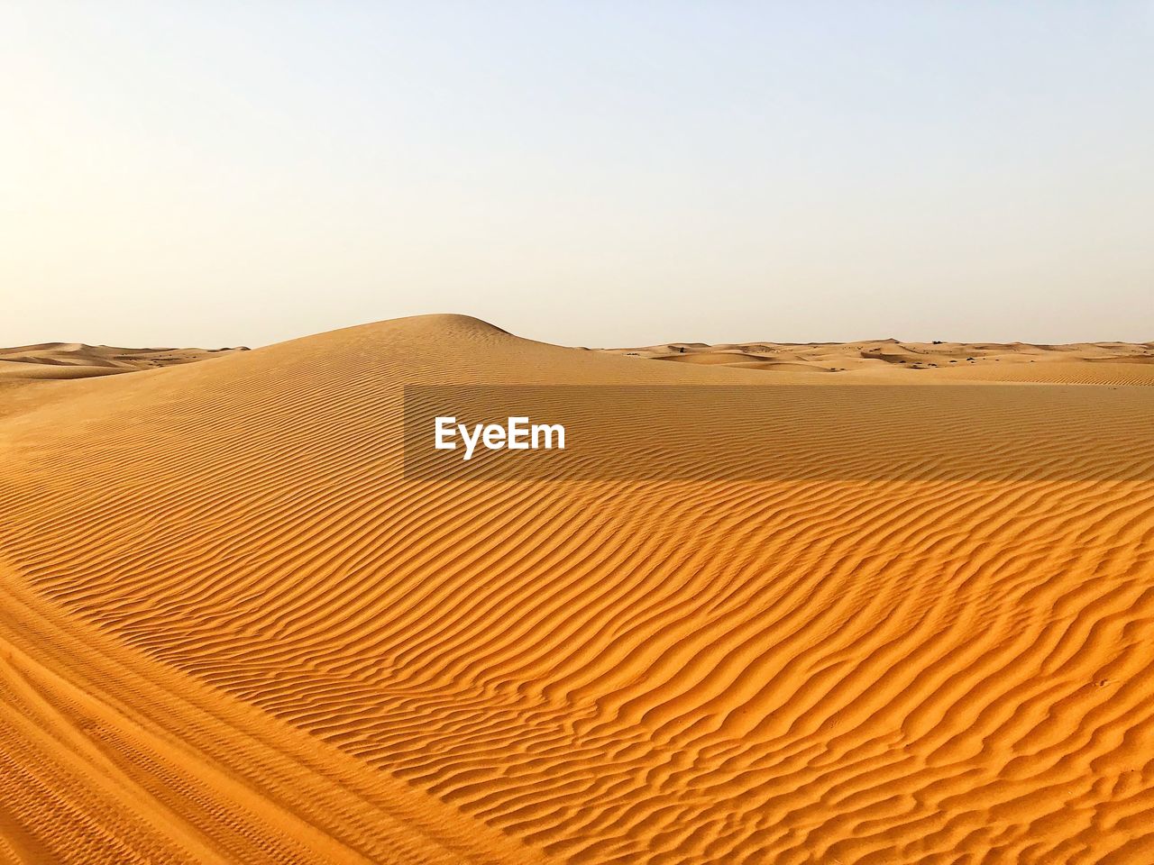 Sand dunes in desert against clear sky