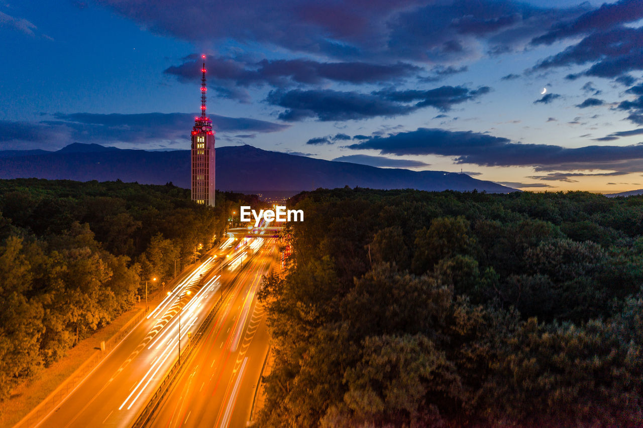 Light trails on road against sky at night