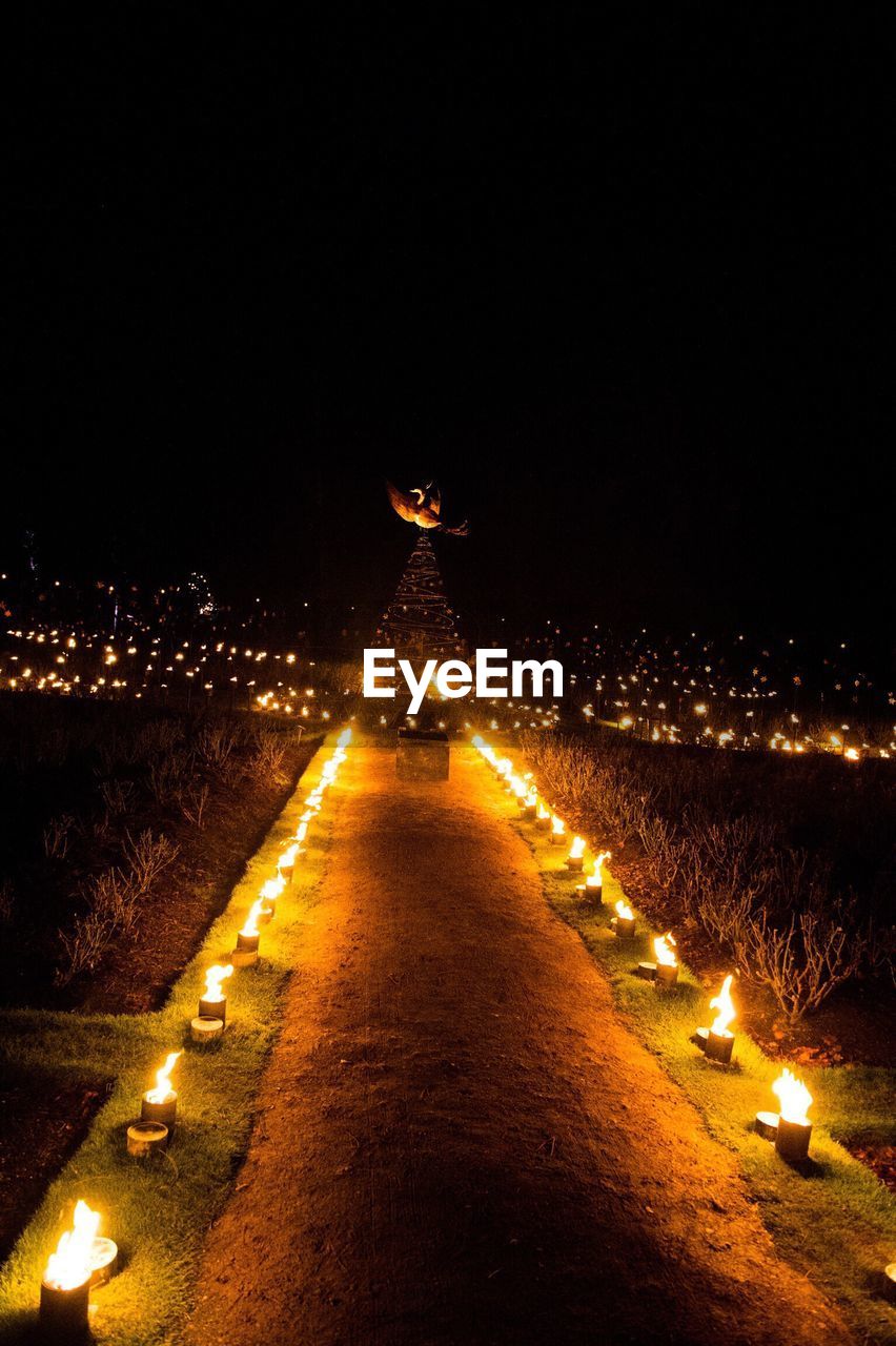 ILLUMINATED CARS AGAINST SKY AT NIGHT