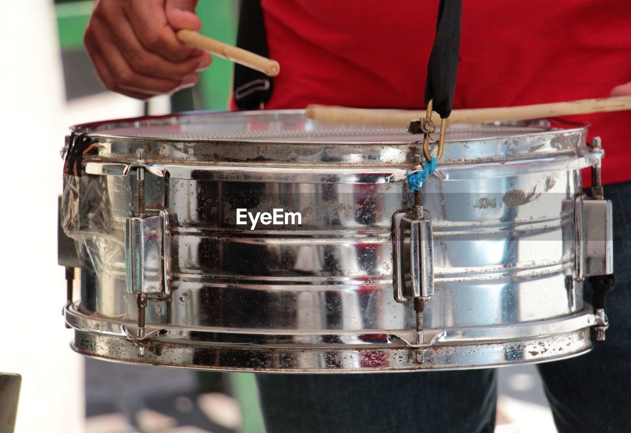 Midsection of musician playing drum