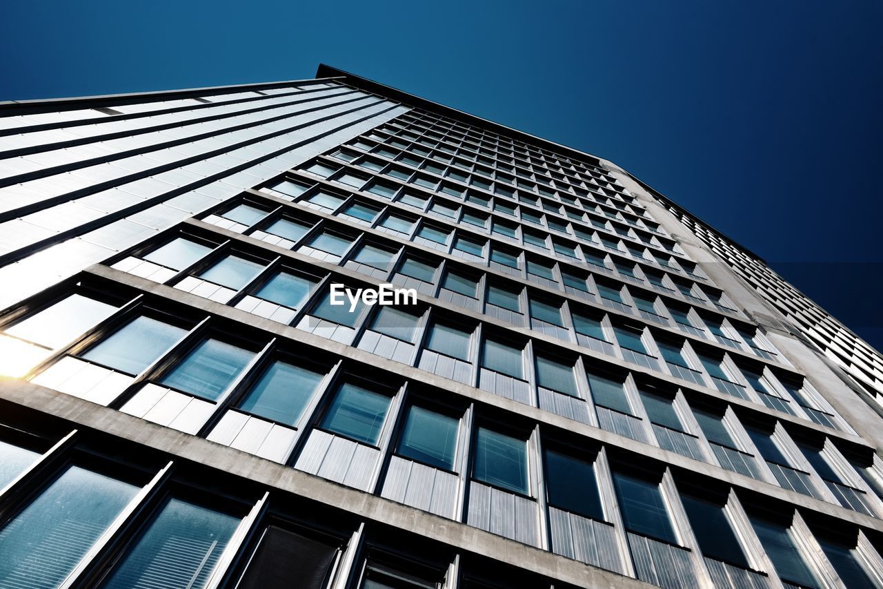 Low angle view of modern building against clear blue sky