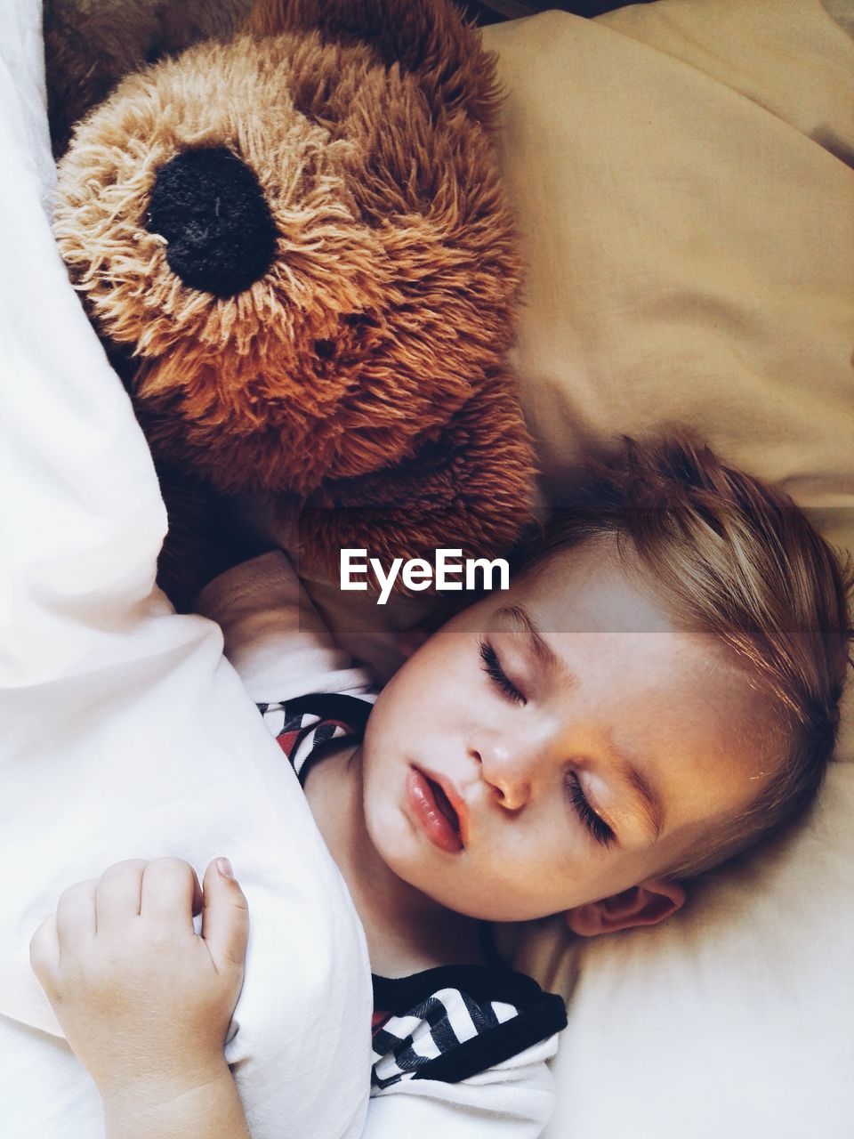 High angle view of boy sleeping on bed at home