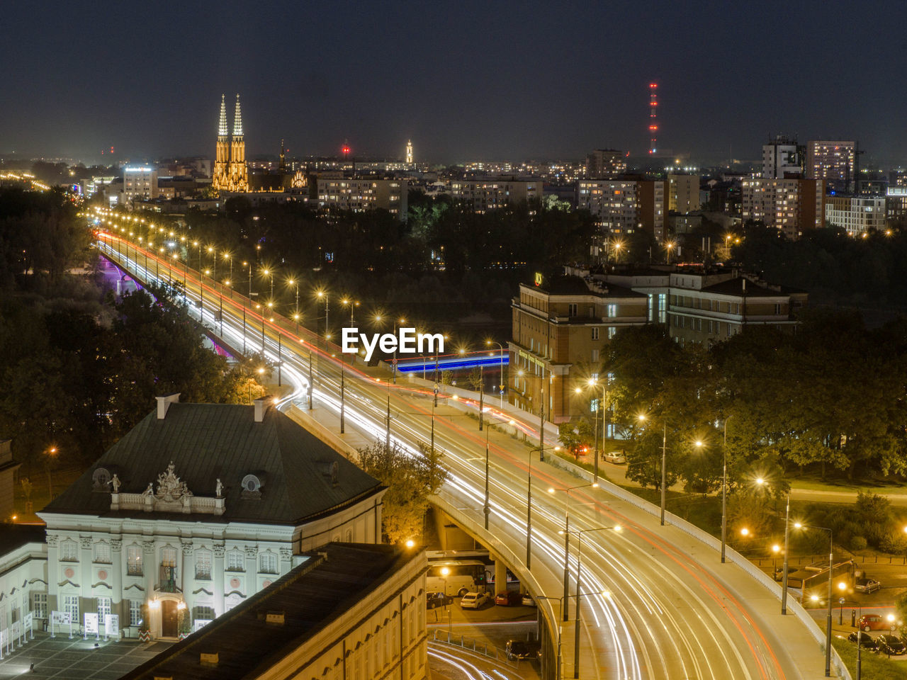 High angle view of illuminated street amidst buildings in city at night