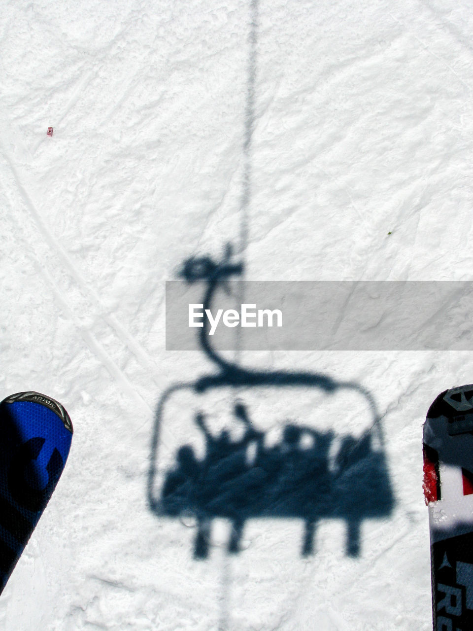 Shadow of people in ski lift on snow