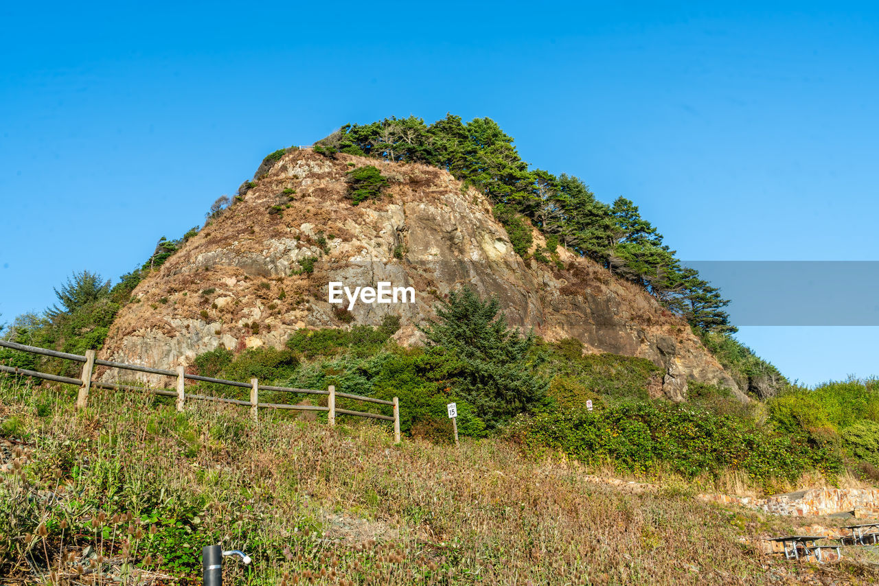 plant, sky, hill, nature, land, landscape, blue, clear sky, no people, environment, tree, scenics - nature, grass, rock, rural area, architecture, beauty in nature, outdoors, travel, travel destinations, day, plateau, tranquility, non-urban scene, built structure, sunny, field, ruins, tourism, tranquil scene, rural scene, green, geology, history, soil, growth, terrain