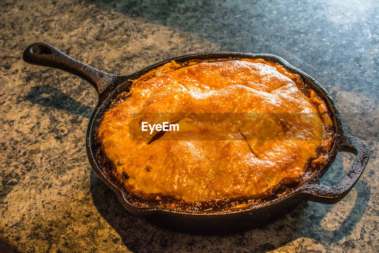 High angle view of apple pie in pan on table