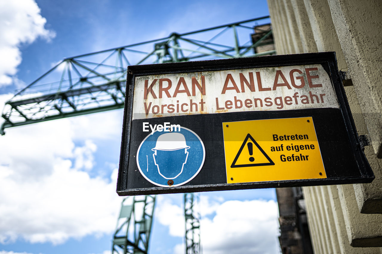 sign, communication, text, cloud, advertising, sky, architecture, western script, guidance, blue, road sign, street sign, no people, low angle view, signage, nature, symbol, road, city, outdoors, warning sign, day, built structure, directional sign, information sign