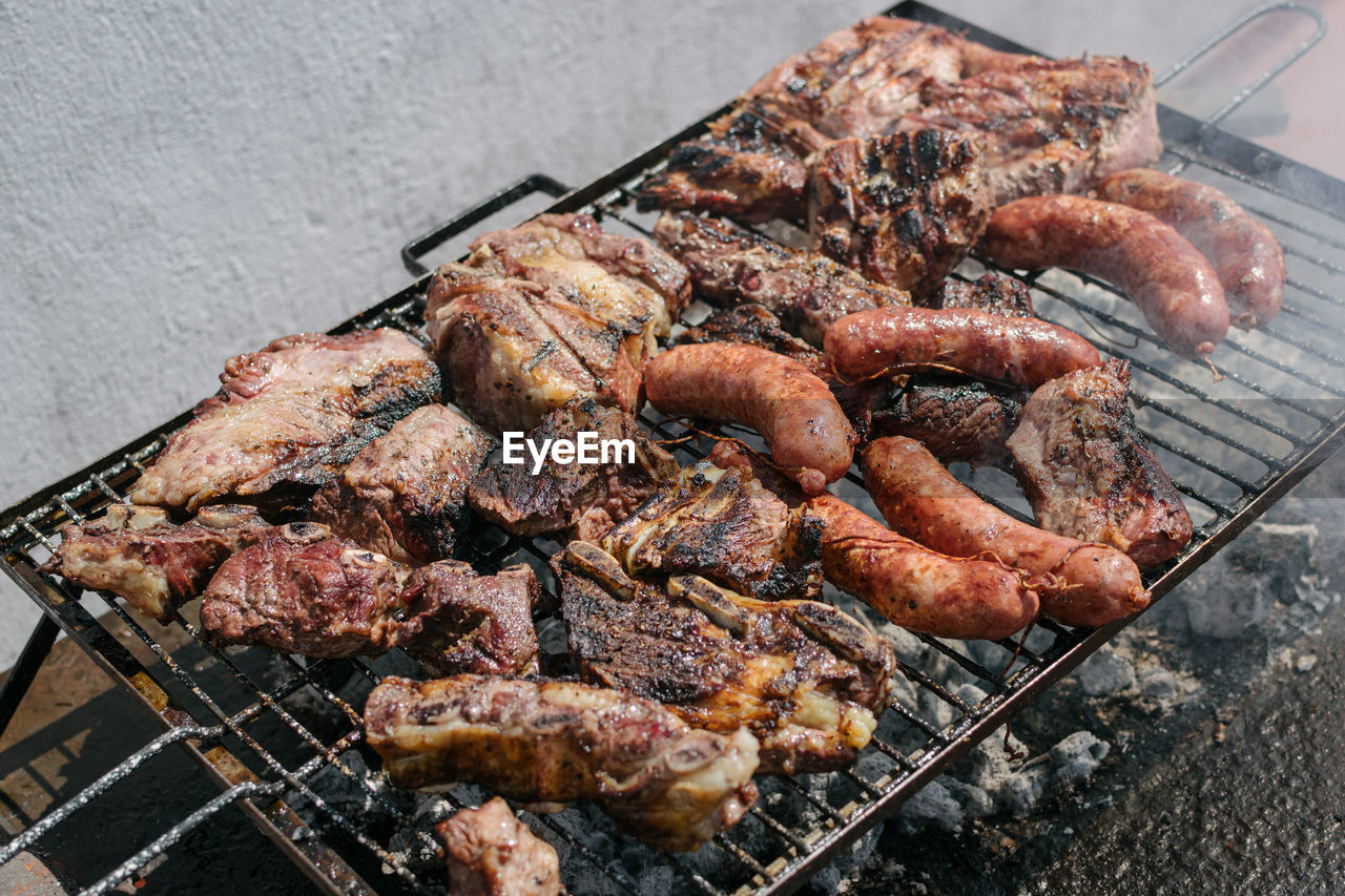 HIGH ANGLE VIEW OF MEAT COOKING ON BARBECUE