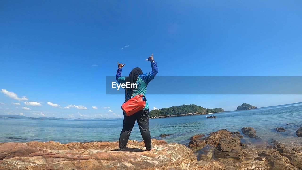 FULL LENGTH OF MAN STANDING ON BEACH