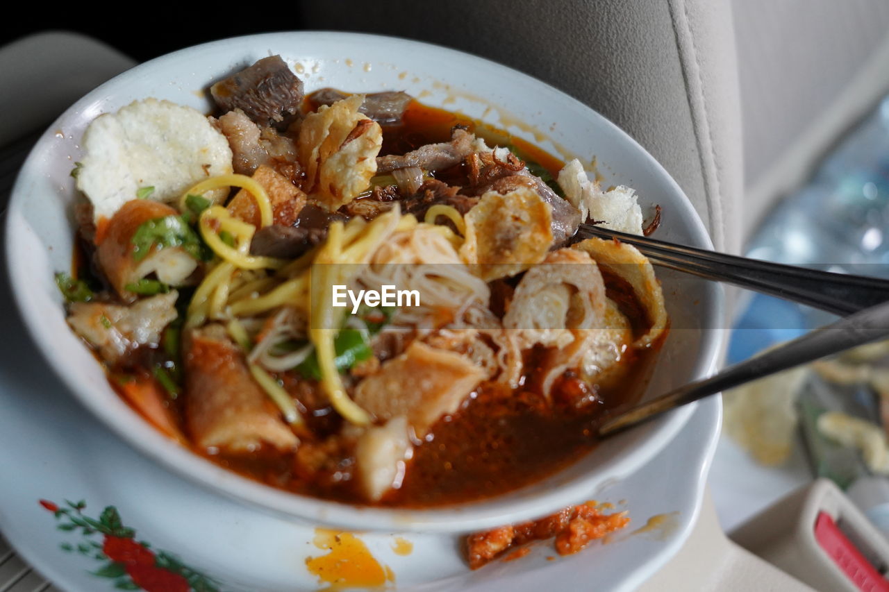 High angle view of noodle soup with spring rolls served in bowl