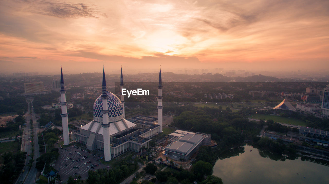 High angle view of city lit up during sunset