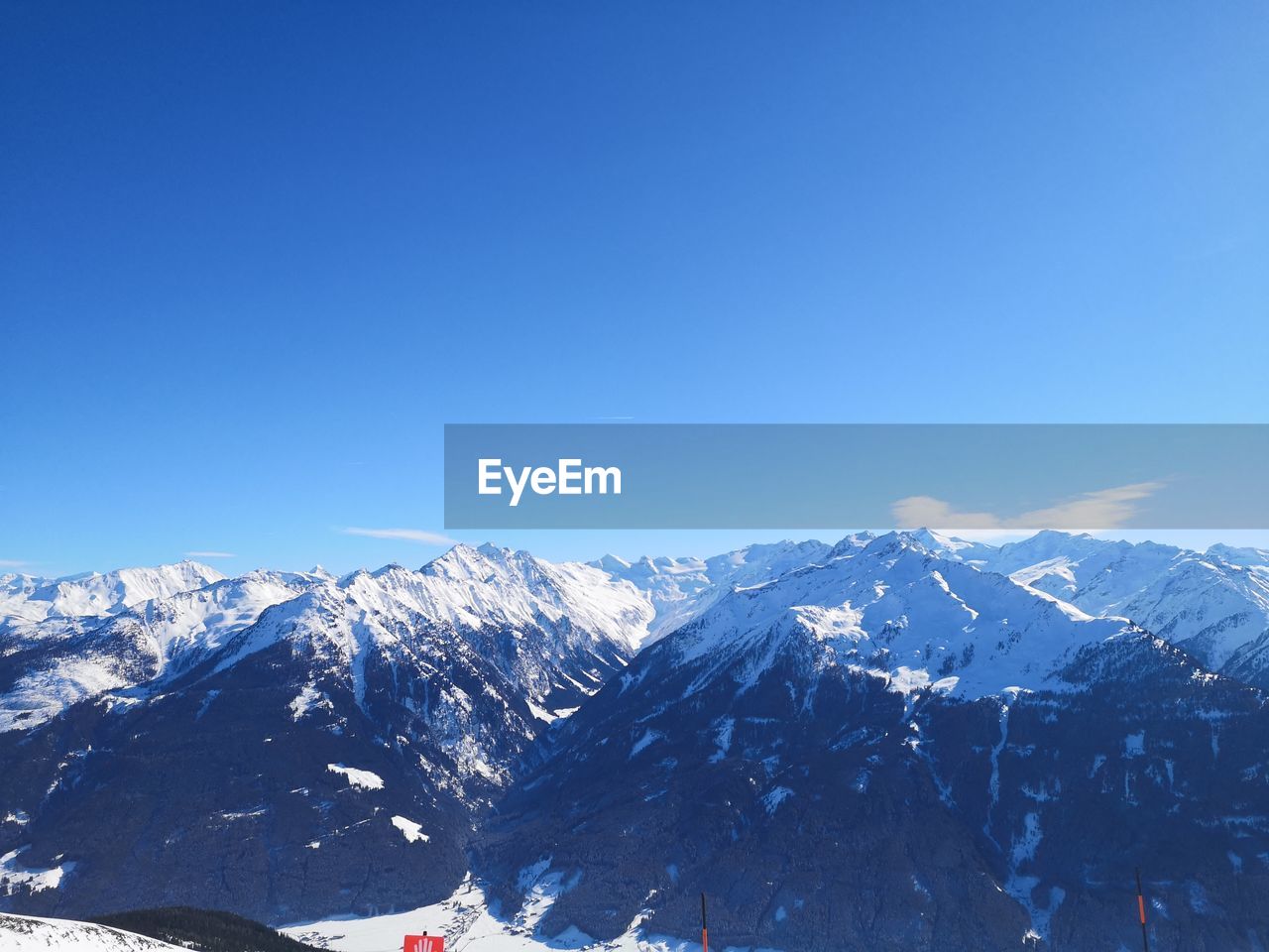 Scenic view of snowcapped mountains against clear blue sky