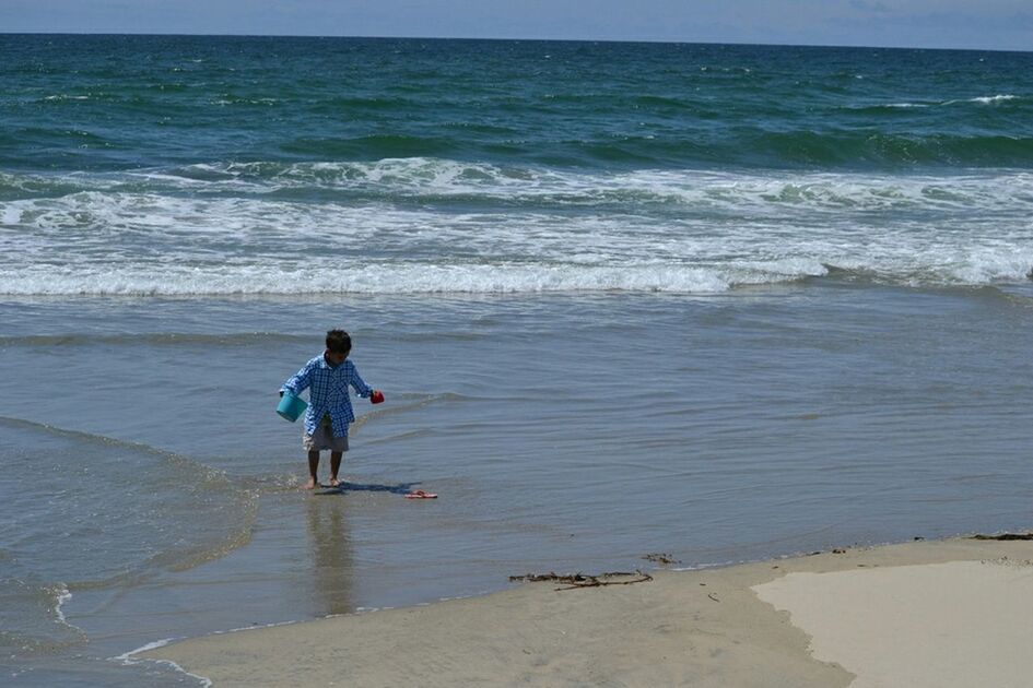 WOMAN STANDING ON BEACH