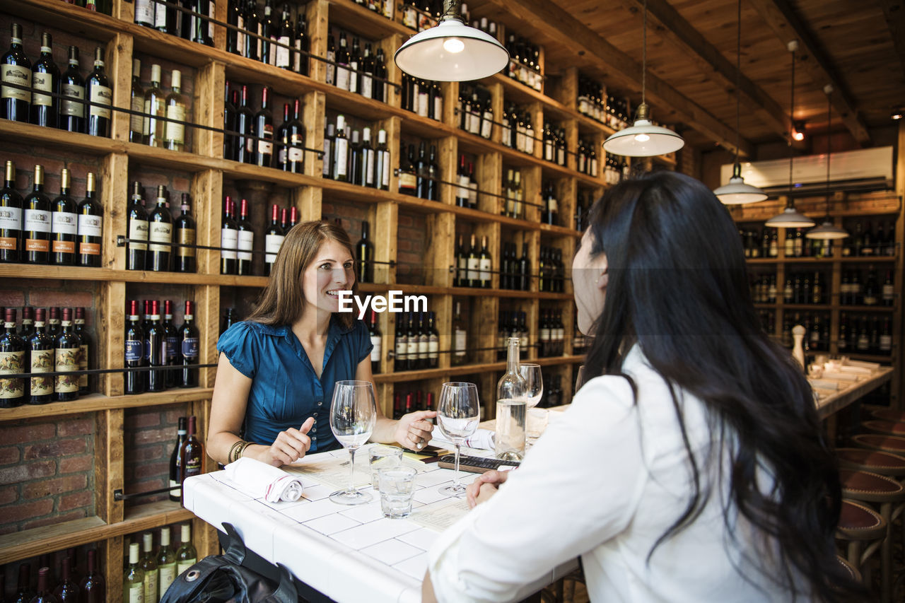 Businesswomen talking while sitting in bar