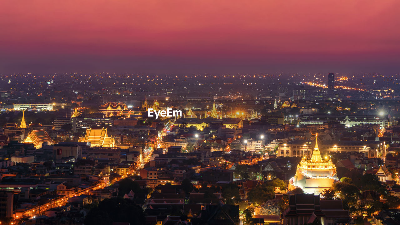 HIGH ANGLE VIEW OF ILLUMINATED BUILDINGS IN CITY