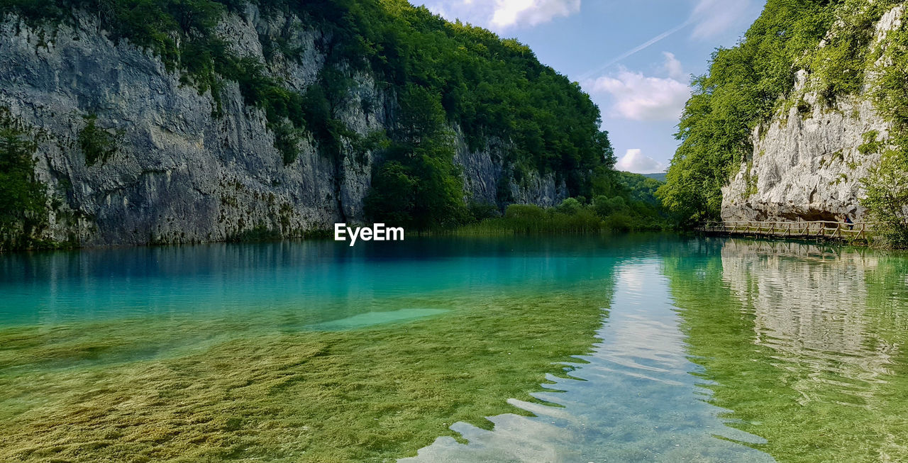 Panoramic view of rocks in water against sky plitvice blue lake in croatia