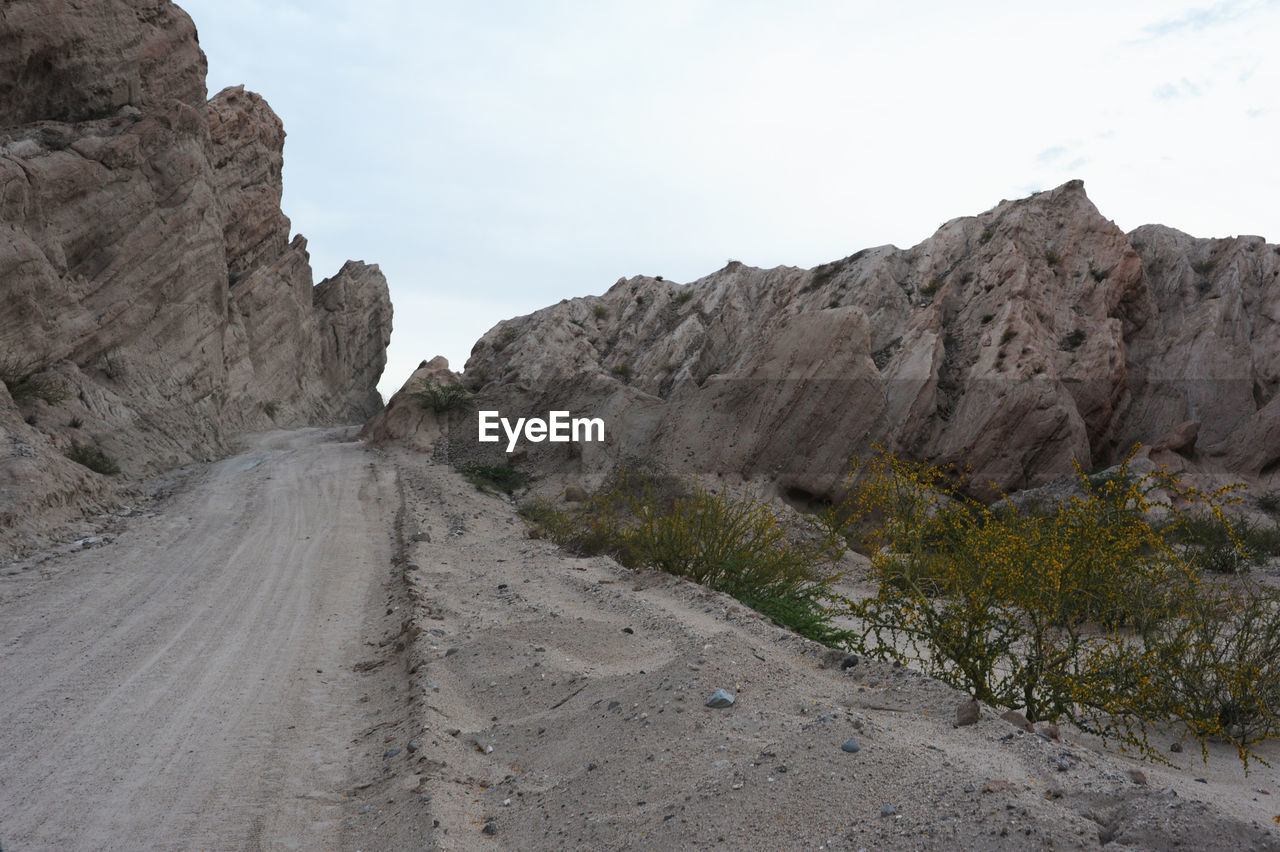 Road amidst mountains against clear sky