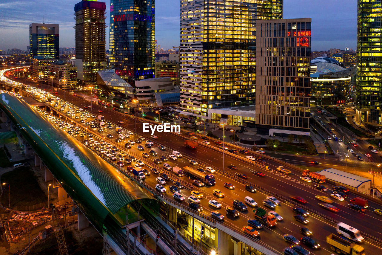 High angle view of illuminated city street and buildings at night