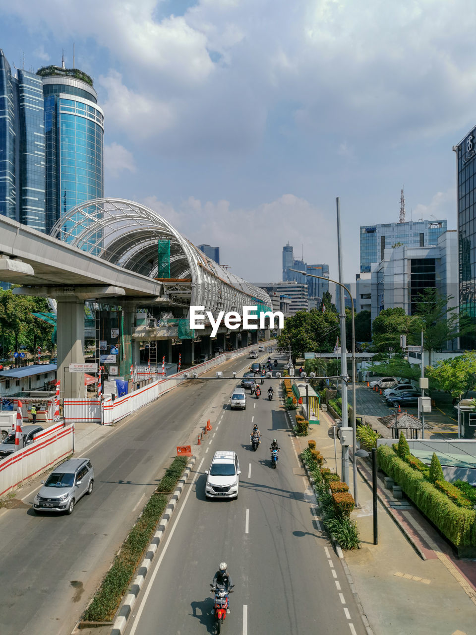 Vehicles on road in city against sky