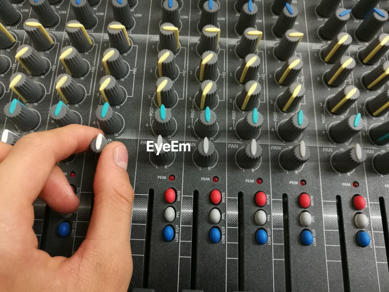 Cropped hands of musician mixing sound with console