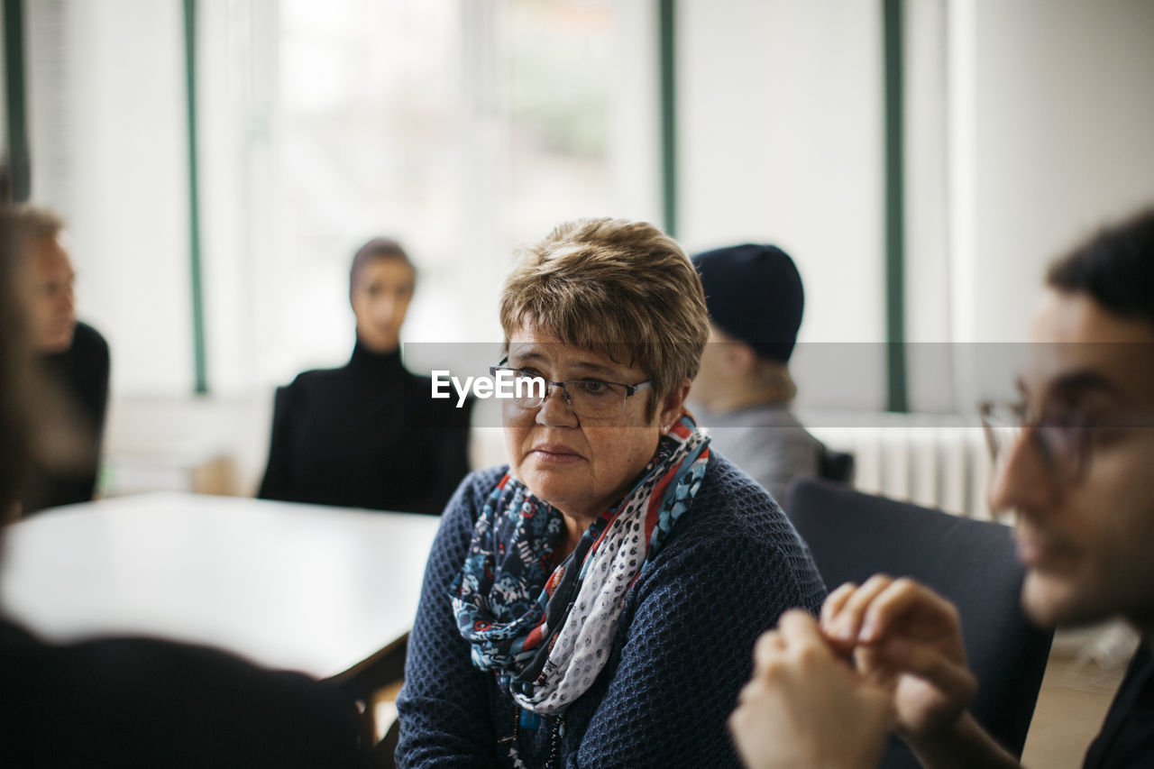 Mature woman listening during informal meeting