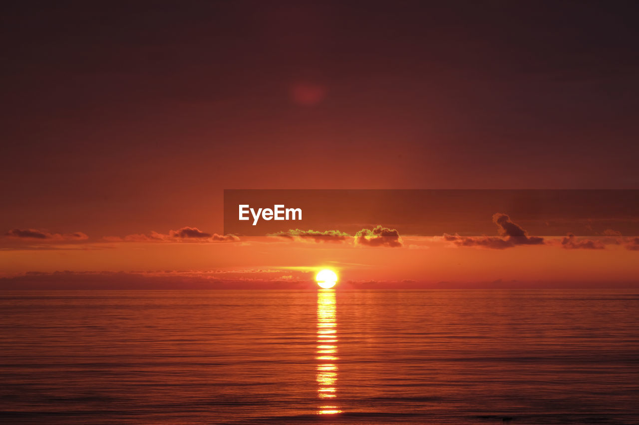 SCENIC VIEW OF SEA AGAINST ORANGE SKY DURING SUNSET