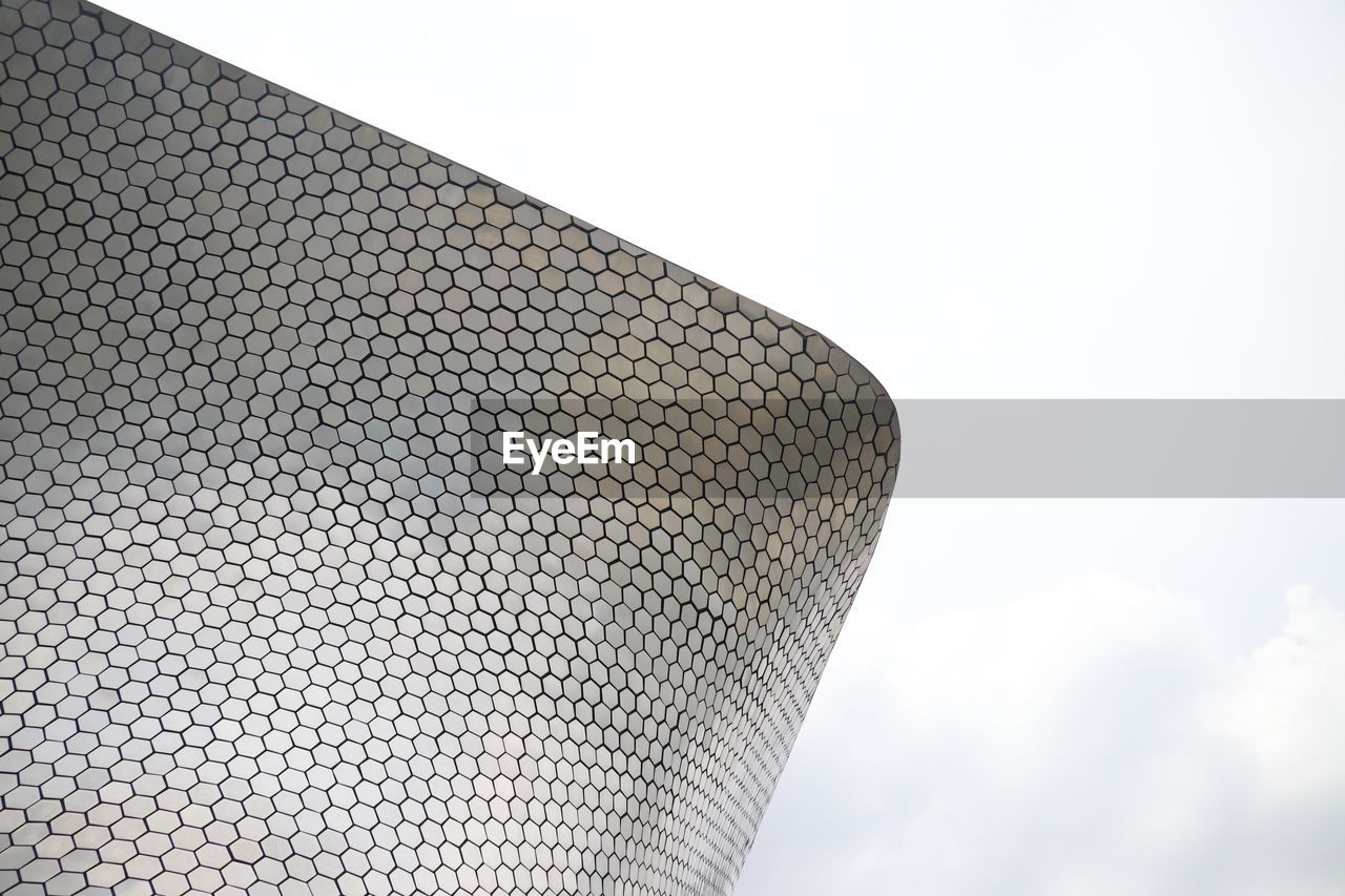 Low angle view of roof against cloudy sky