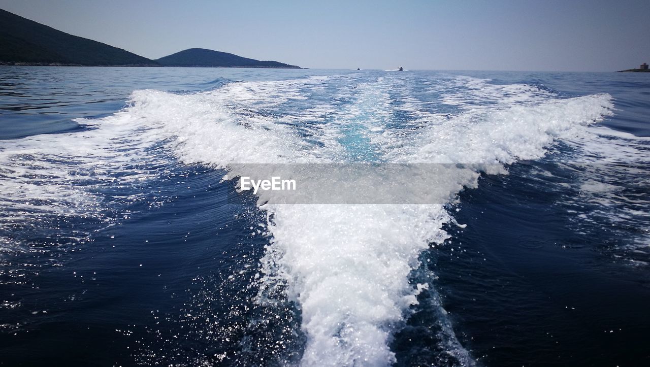 Waves splashing on sea against sky