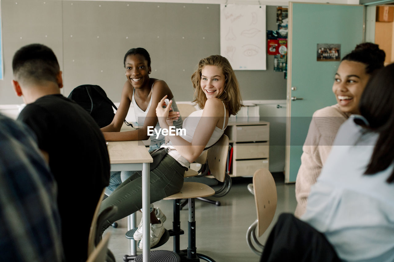 Smiling female students sitting in classroom