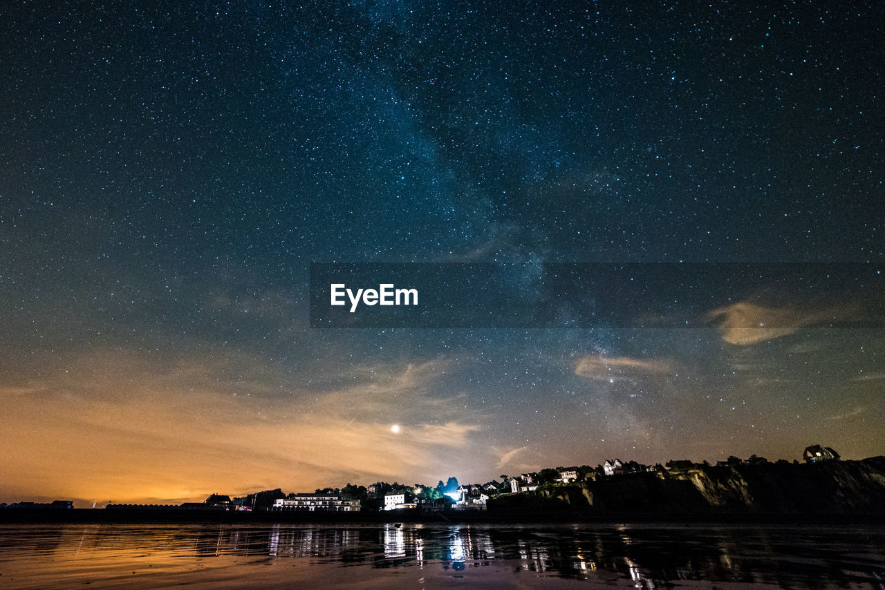 Scenic view of lake against sky at night