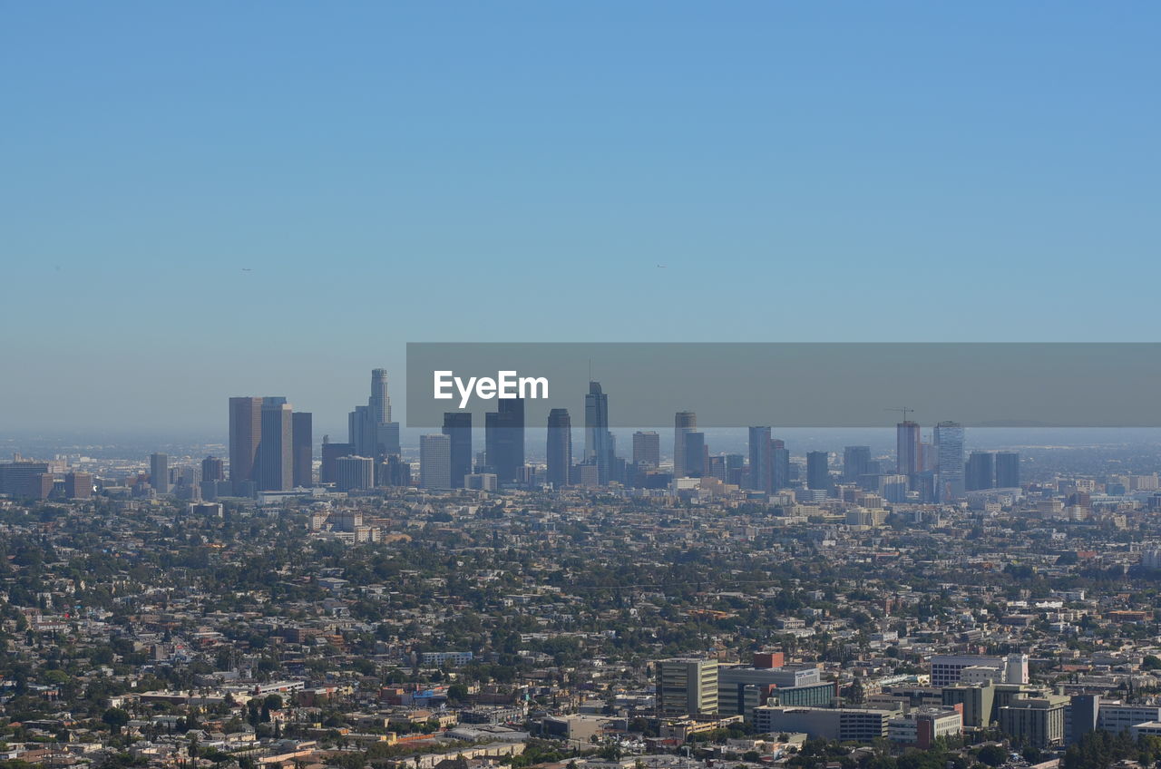 Aerial view of modern buildings in city against clear sky