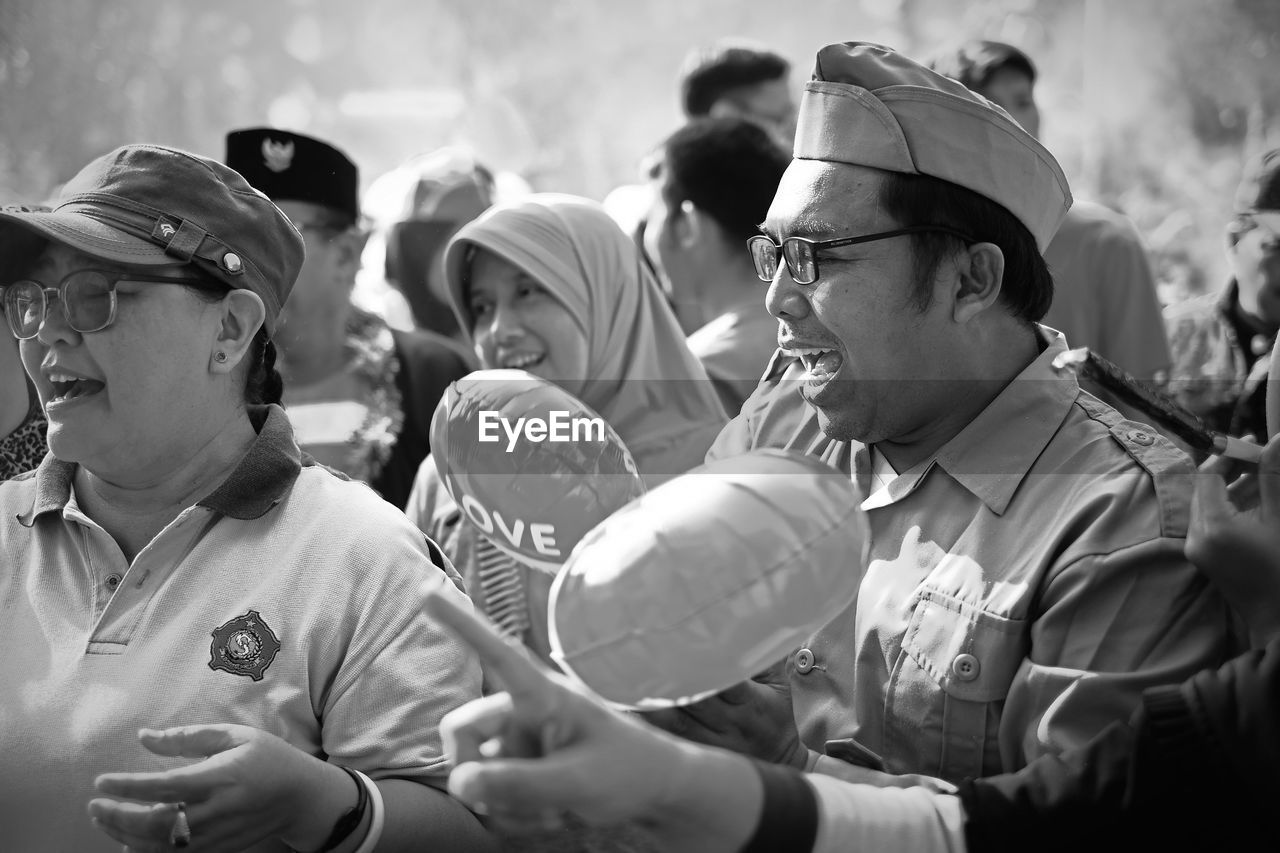 GROUP OF PEOPLE LOOKING AT TRADITIONAL CLOTHING