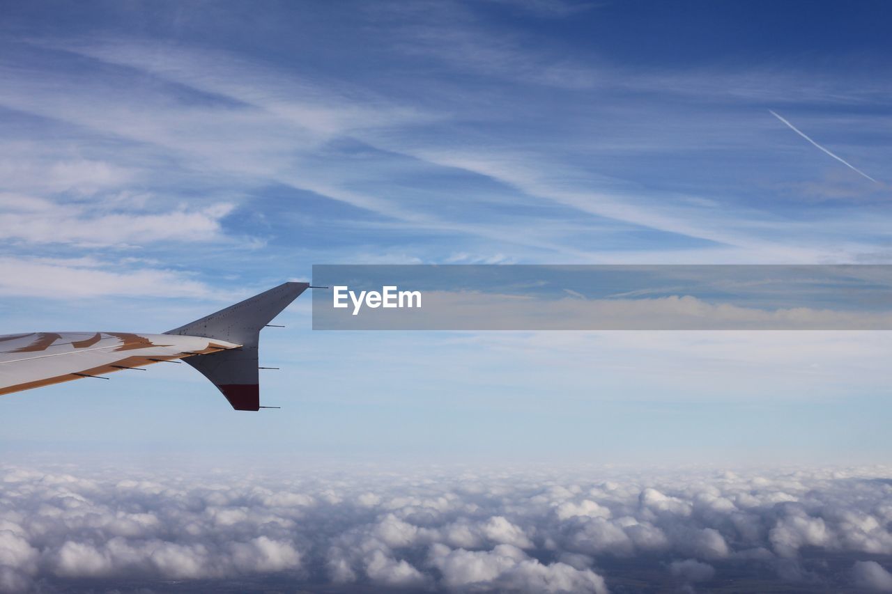 AIRPLANE WING AGAINST SKY