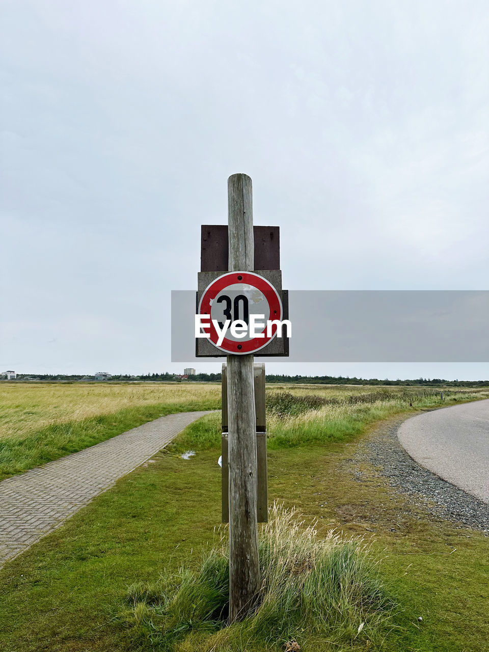sign, sky, road, road sign, grass, communication, nature, traffic sign, guidance, cloud, no people, plant, day, speed limit sign, landscape, transportation, warning sign, signage, land, environment, symbol, information sign, rural area, outdoors, field, walkway, wind, tranquility, non-urban scene, number, tranquil scene, scenics - nature