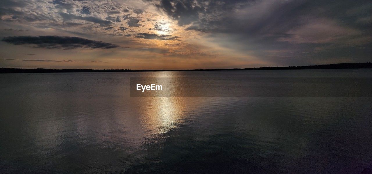 water, sky, reflection, cloud, sea, beauty in nature, scenics - nature, sunset, dawn, nature, horizon, tranquility, sunlight, environment, dramatic sky, evening, tranquil scene, no people, beach, landscape, seascape, land, horizon over water, outdoors, sun, cloudscape, ocean, travel destinations, idyllic