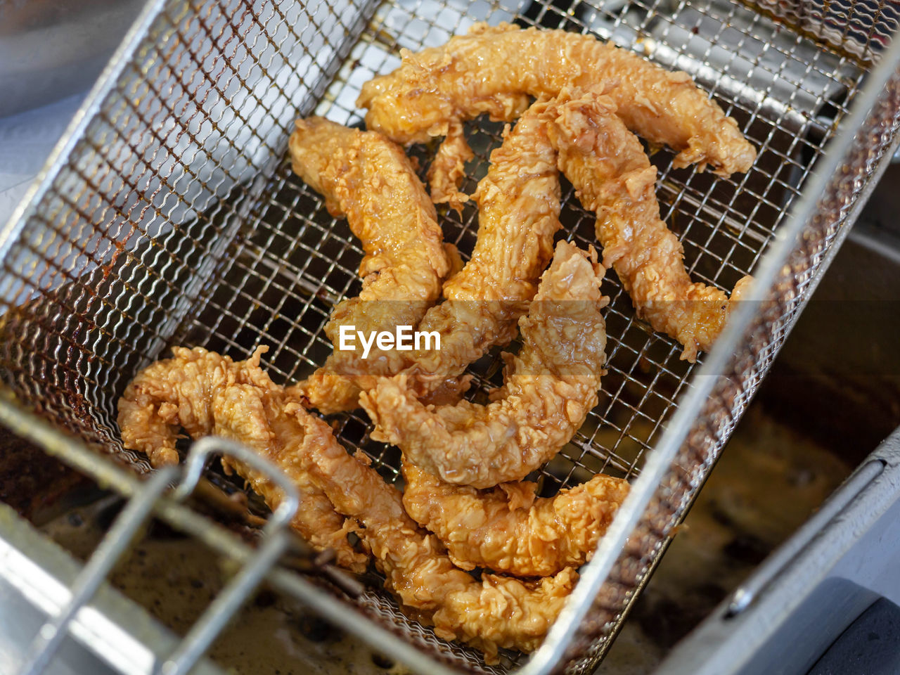 The boiling oil frying of the nuggets is complete. large chunks of deep-fried chicken 